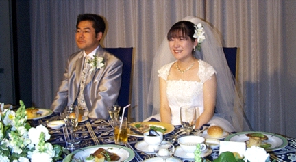 Bride and Groom Listen to Speeches and Entertainment